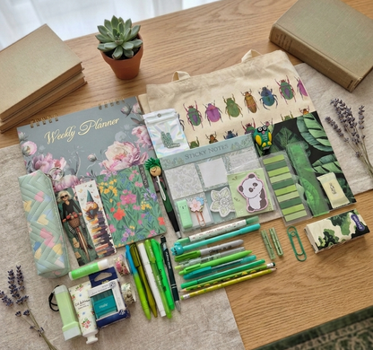 Contents of a stationery surprise box including notebooks charms and planners